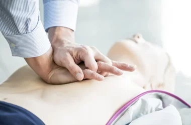 first-aider-practising-chest-compressions-973899470-8d6d04a519064603a238fb20c025669c